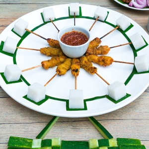 mini-satay-970x526-v2 A white plate with sticks of chicken satay and lontong cubes arranged to form the shape of the Singapore Flyer