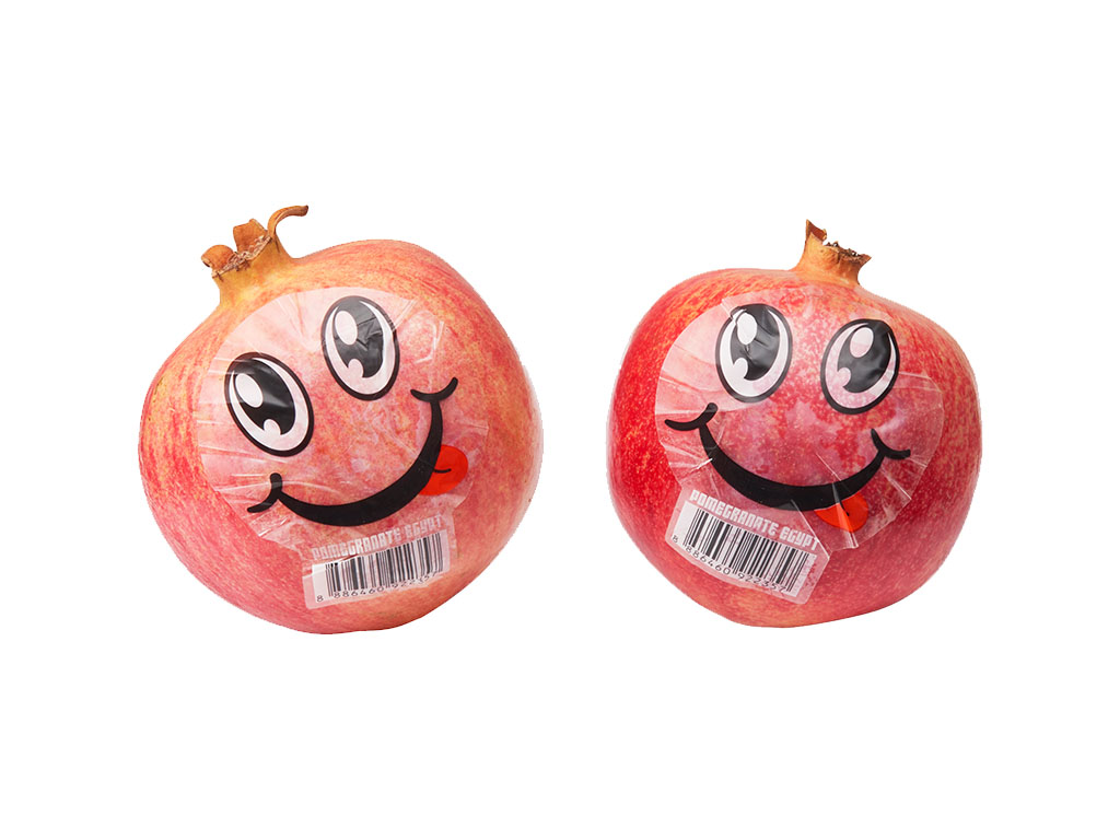 Two Egypt pomegranates with a smiling face sticker Two Egypt pomegranates with a smiling face sticker