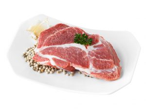 Slice of pork shoulder butt on a plate Slice of pork shoulder butt on a white plate