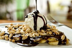 Chocolate crepe and vanilla ice cream, French food, banana and peanuts toppings Chocolate crepe and vanilla ice cream, French food, banana and peanuts toppings