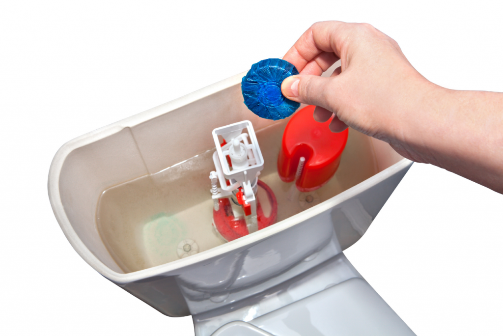 Dropping toilet cleaner tablet into tank