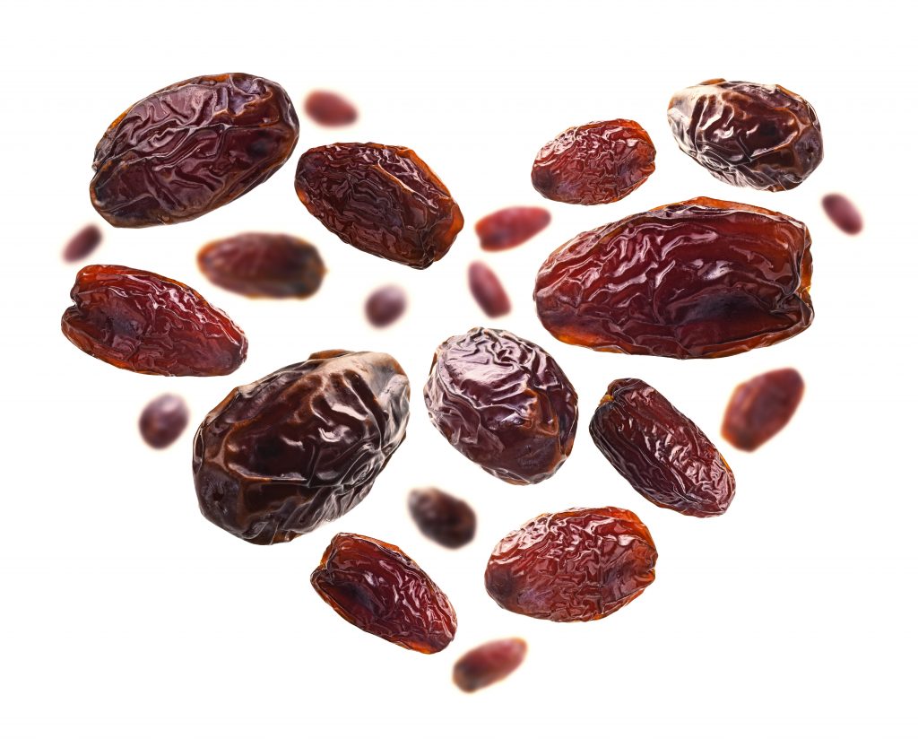 Dried dates in the shape of a heart on a white background