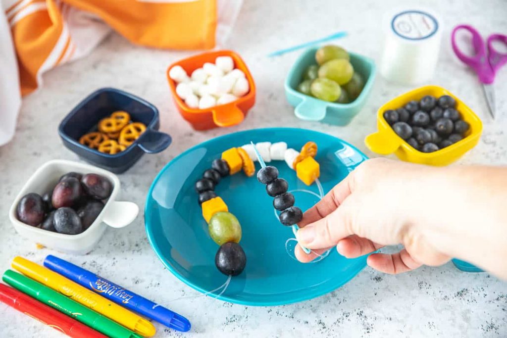 Edible snack necklace on a blue plate for kids