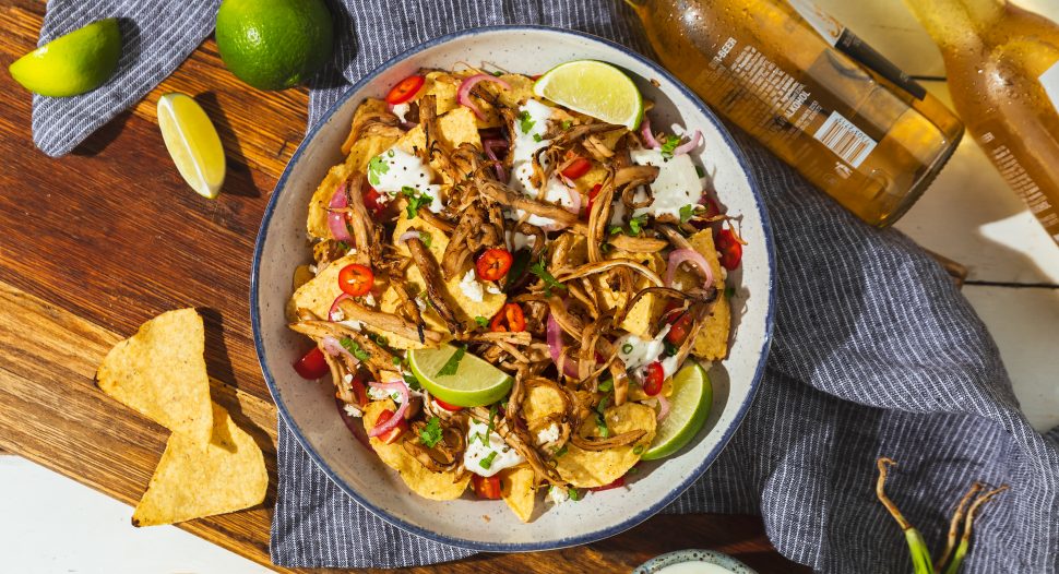 Beer braised pulled chicken on top of crispy tortilla chips topped with onions, sour cream and sauerkraut