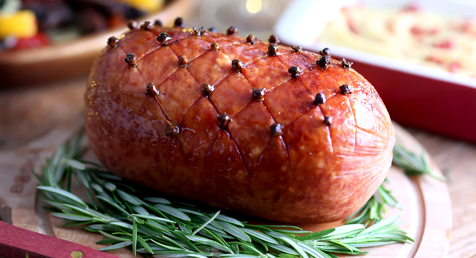scored christmas ham served with creamy mash and roasted vegetables