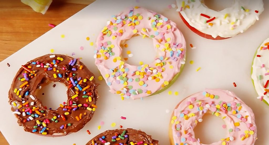 Fresh apple rings covered in cream and sprinkles