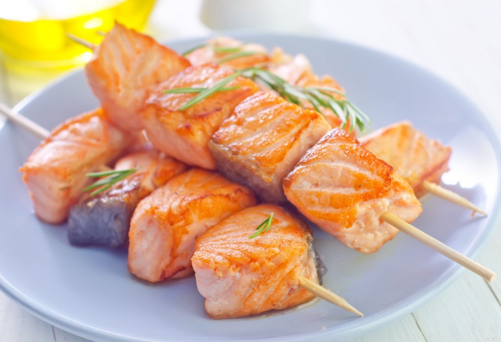 Salmon kebab on plate and on a table
