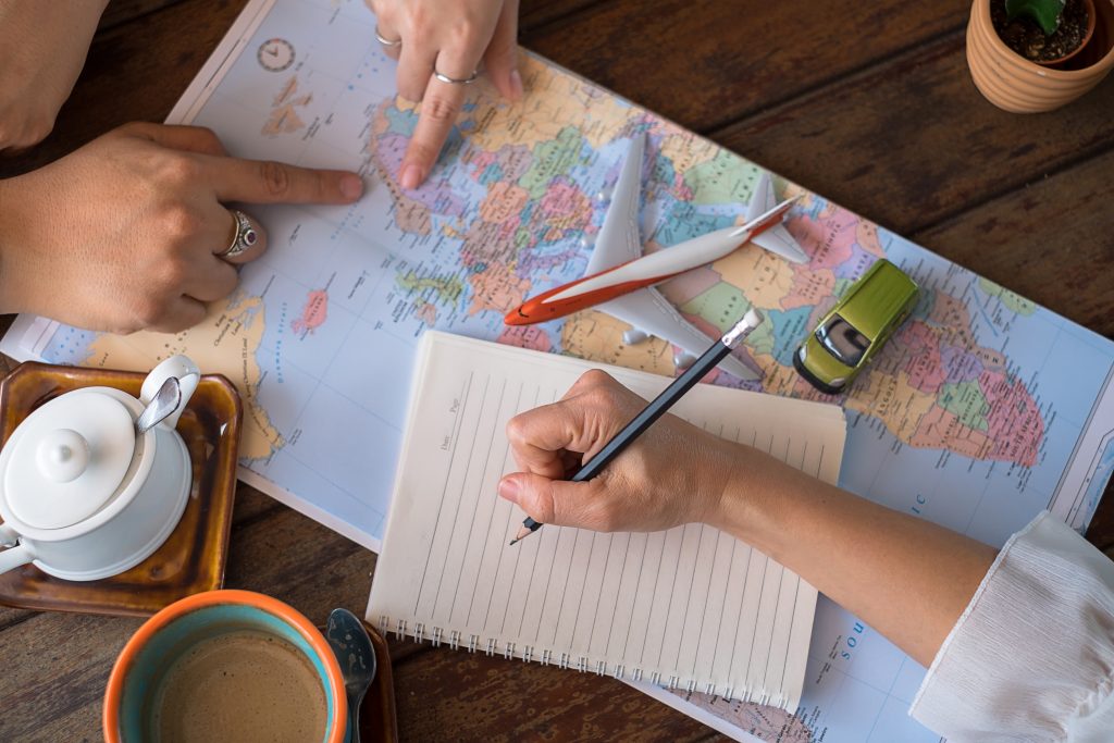 Young,Couple,Planning,Honeymoon,Vacation,Trip,With,Map.,Top,View.