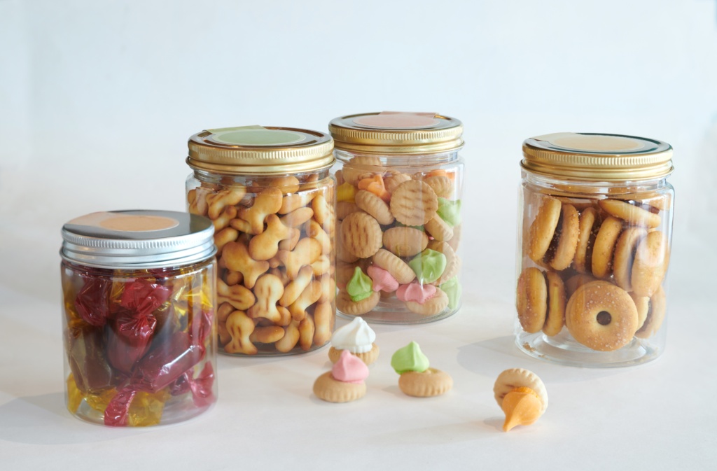 Old-school Biscuits Four transparent containers with golden lids, full of old-school biscuits like fish crackers and iced gem biscuits