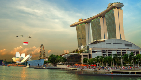 A Singapore flag being flown by 3 helicopters at the Marina Bay area.