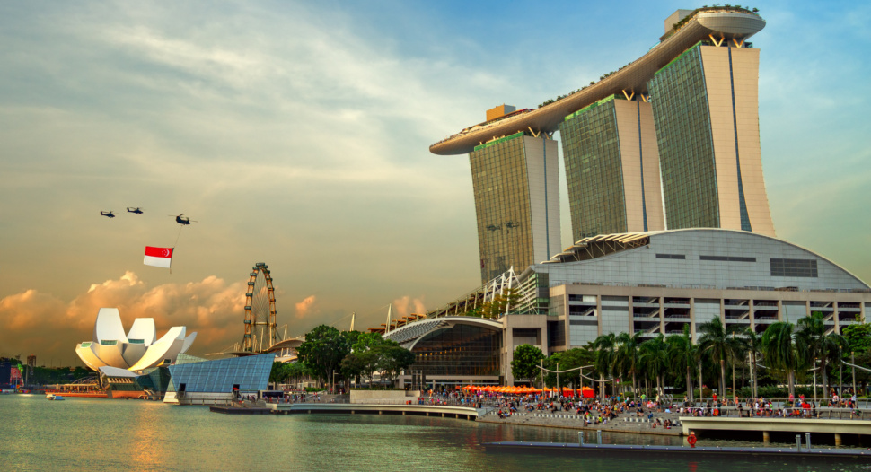 A Singapore flag being flown by 3 helicopters at the Marina Bay area.